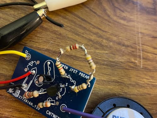 A circuit board with several resistors wired in a weird way. Also, crocodile clip connections in the background